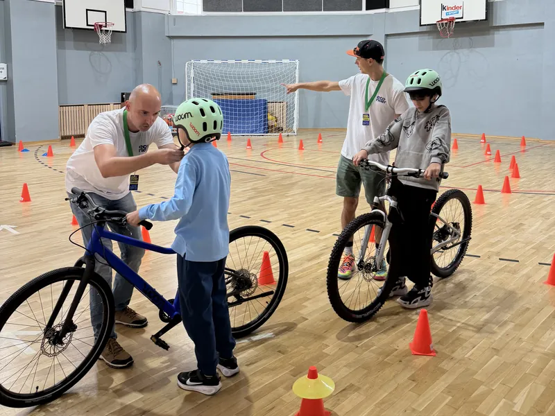 Trainerii EcoRider verifică echipamentul de protecție și poziția copiilor pe bicicletă